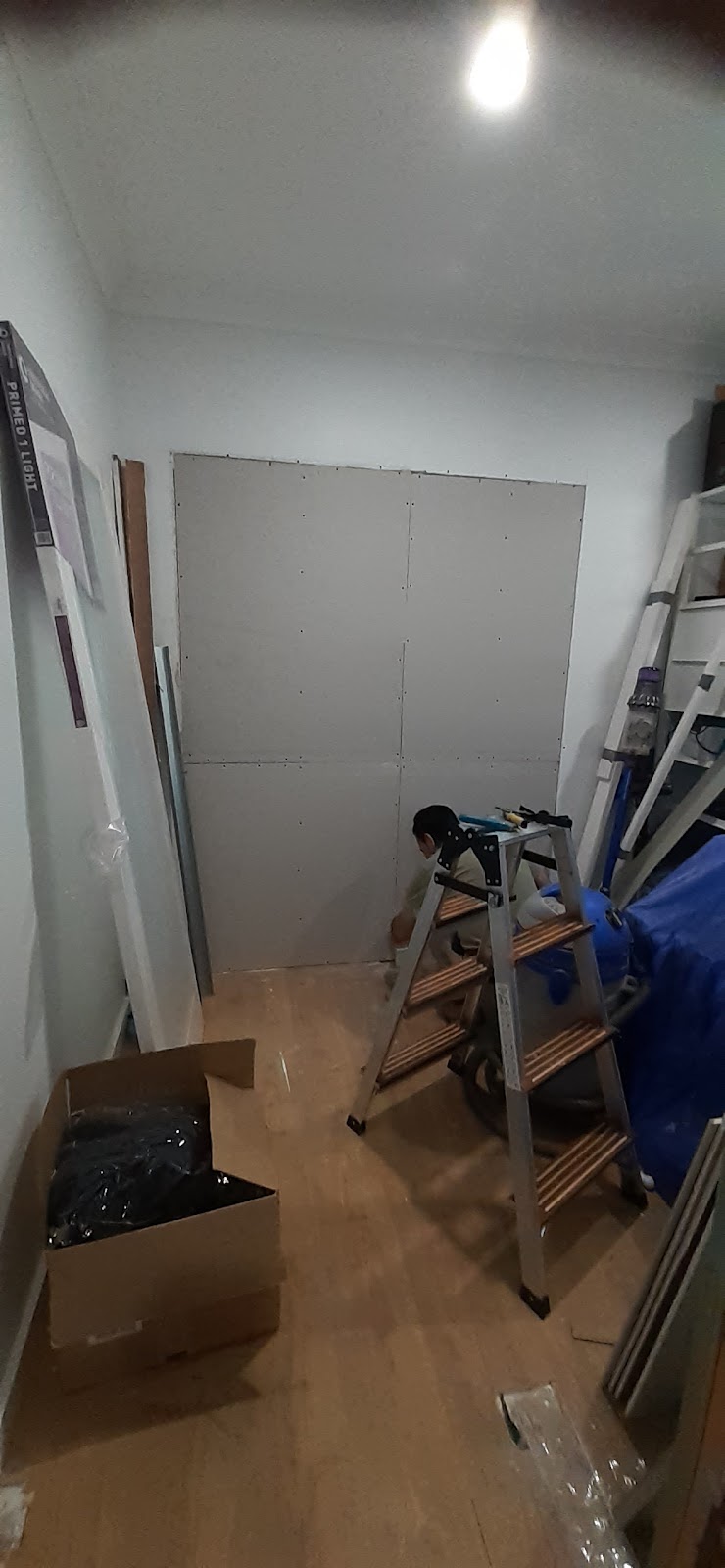 Hallway mid-job with a ladder and plasterboard